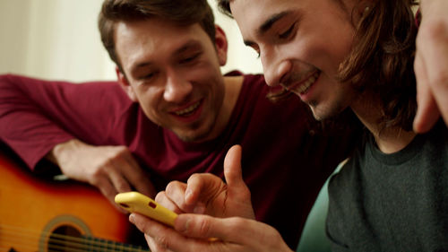 Smiling men looking at mobile phone
