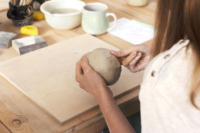 Woman's hands sculpt from a clay. pottery workshop class.