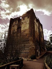 Low angle view of old building against cloudy sky