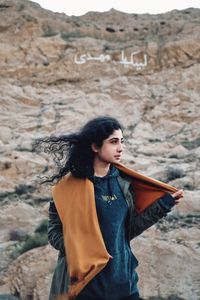 Full length of young woman standing on mountain