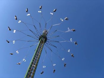 Low angle view of chain swing ride against clear blue sky