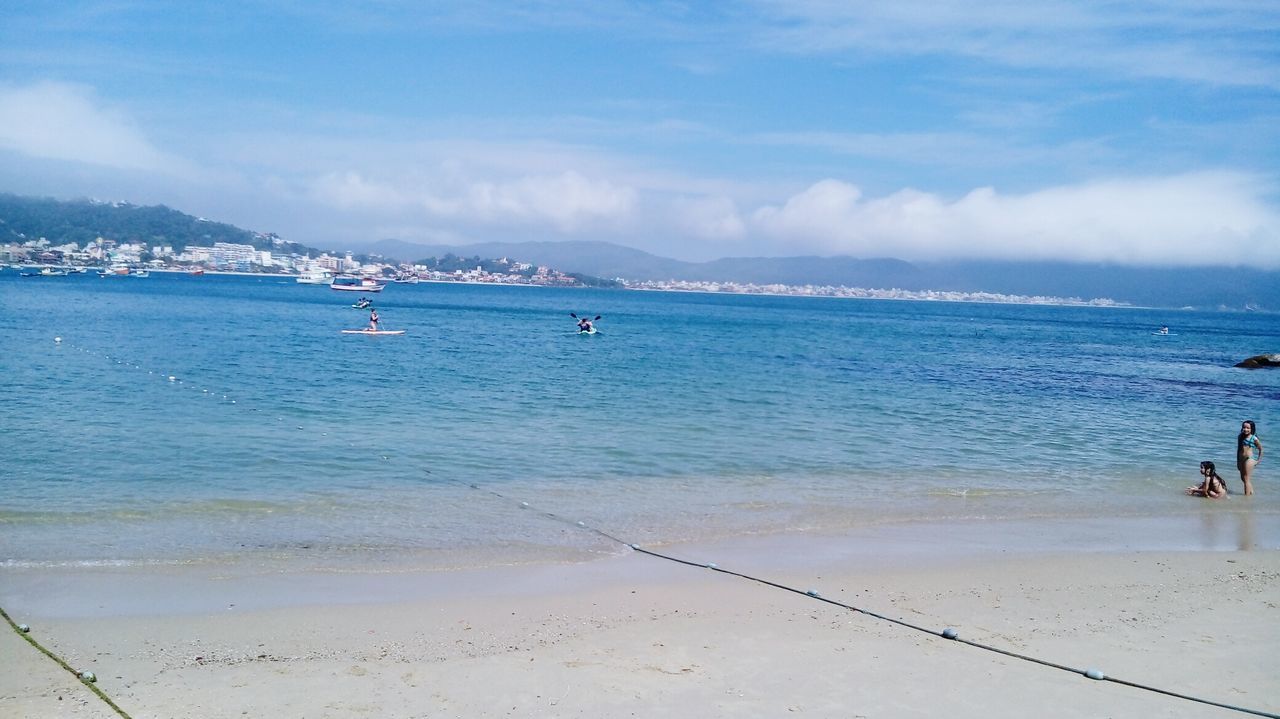 beach, sea, water, shore, sand, nautical vessel, blue, vacations, mountain, tranquil scene, tourism, scenics, sky, mode of transport, tranquility, nature, coastline, cloud - sky, travel destinations, beauty in nature, day, distant, outdoors, summer