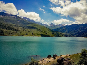 Scenic view of lake by mountains against sky