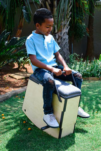 Full length of boy sitting in yard