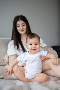 Portrait of cute baby boy lying on bed at home