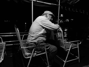 Side view of man sitting on chair