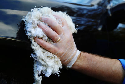 Close-up of man hand cleaning car at garage