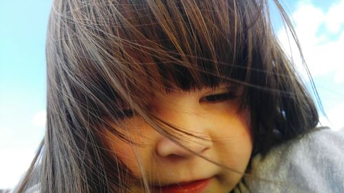 Close-up of girl against sky