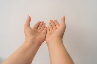 Close-up of hands against white background