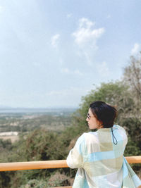 Rear view of woman looking at sea against sky