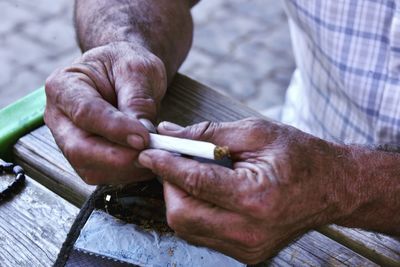 Midsection of man working with cigarette