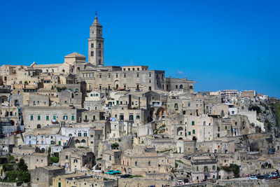 View of buildings in city against blue sky