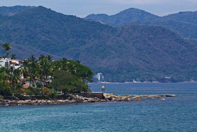 Scenic view of sea and mountains against sky