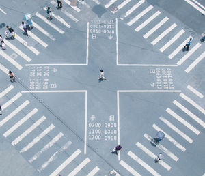 High angle view of people walking on zebra crossing