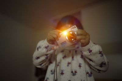 Close-up of hand holding lit candle