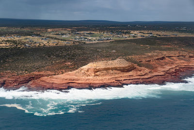 Aerial view of rock formations in sea against sky