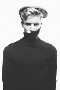 Portrait of young man standing against white background