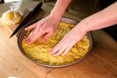 Cropped hands of person preparing food on table