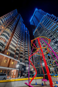 Low angle view of illuminated modern buildings in city at night
