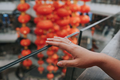 Close-up of hand holding orange leaf against blurred background