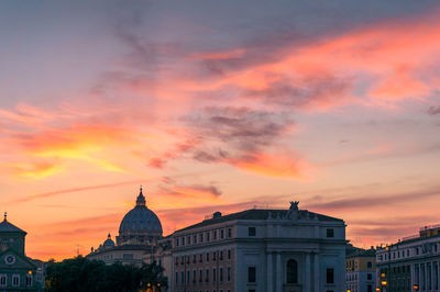 Buildings against cloudy sky at sunset