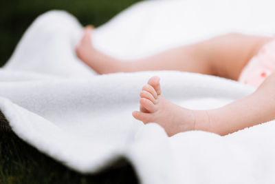 Low section of baby relaxing on blanket