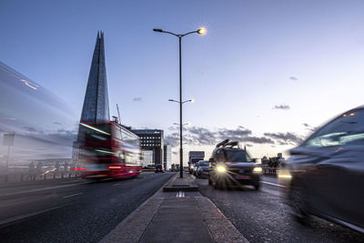 Cars on street in city against sky