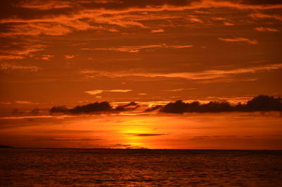 Scenic view of sea against dramatic sky during sunset