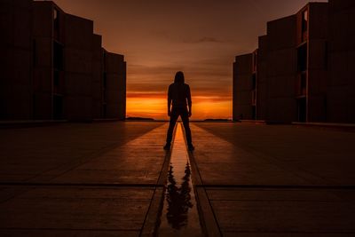 Rear view of man standing against sky during sunset