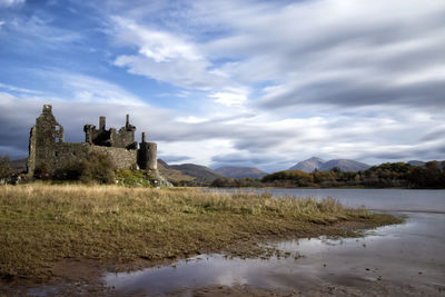 Historic building by lake against sky