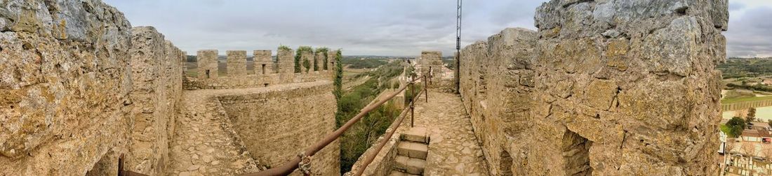 Panoramic view of fortified wall landscape against sky