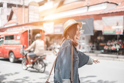 Woman with umbrella walking on street in city