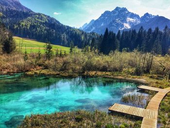 Scenic view of lake by mountains against sky