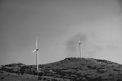 Windmill on landscape against sky