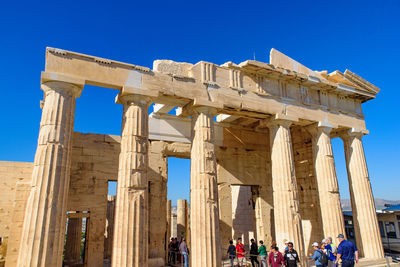 Tourists at historical building against clear sky