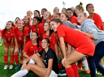 Portrait of young couple sitting on soccer field