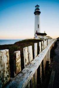 Lighthouse by sea against sky