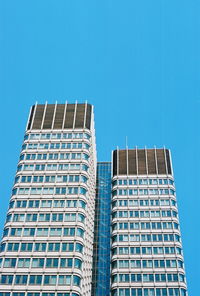 Low angle view of office building against blue sky