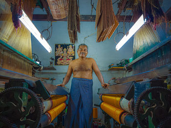 Portrait of shirtless man standing against the wall