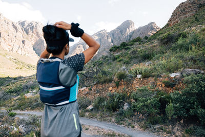 Rear view of man photographing while standing on mountain