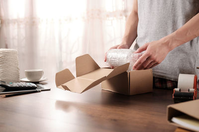 Midsection of businessman packing on table