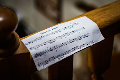 High angle view of sheet music on wooden railing