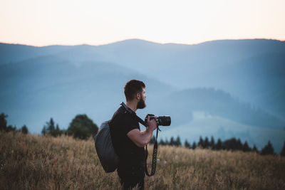 Full length of man photographing on field