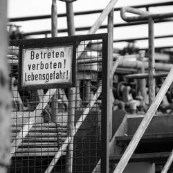 Close-up of information sign on railing