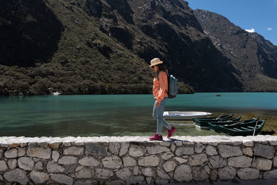Rear view of woman standing by lake