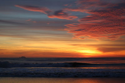 Scenic view of sea against orange sky durin sunrise 