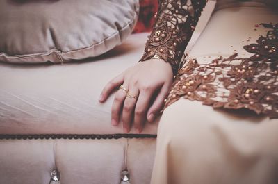 Midsection of woman sitting on sofa