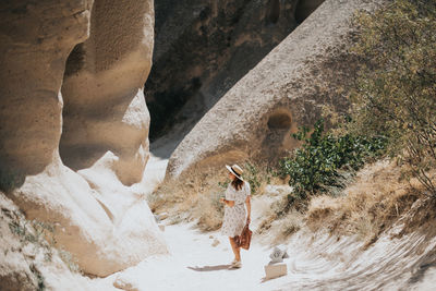 Rear view of woman walking on rock formation