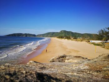 Scenic view of beach against clear blue sky