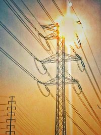 Close-up of electricity pylon against sky during sunset